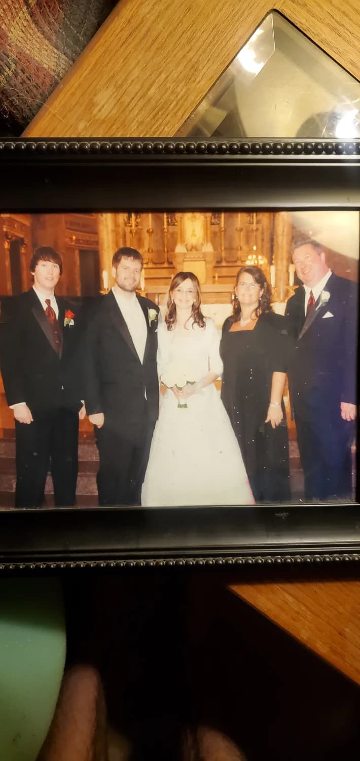 Michael and his wife on their wedding day, family gathered around